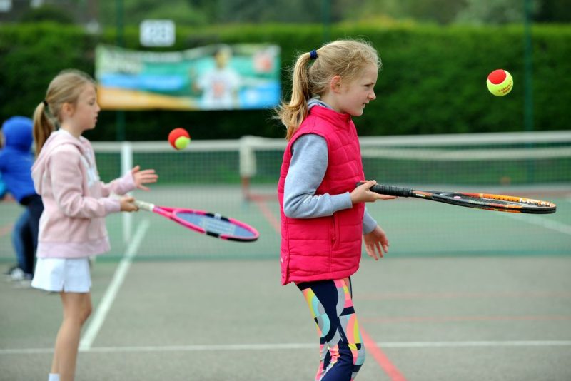 Girls in tennis coaching session